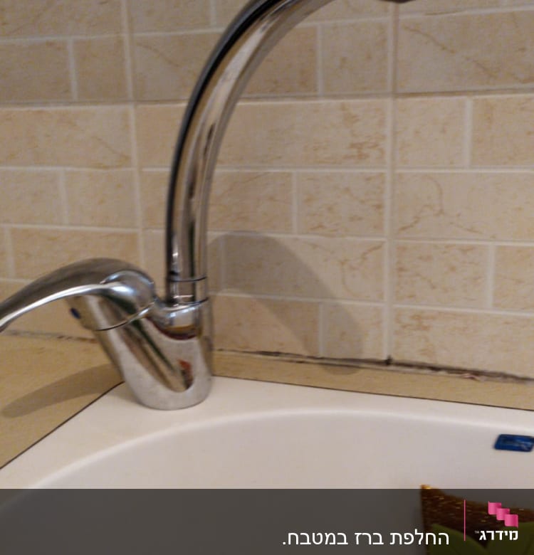 ברז מטבח כסוף מעל כיור לבן